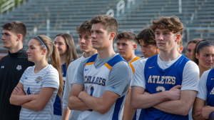 Student-athletes wearing uniforms gathered on a sports field
